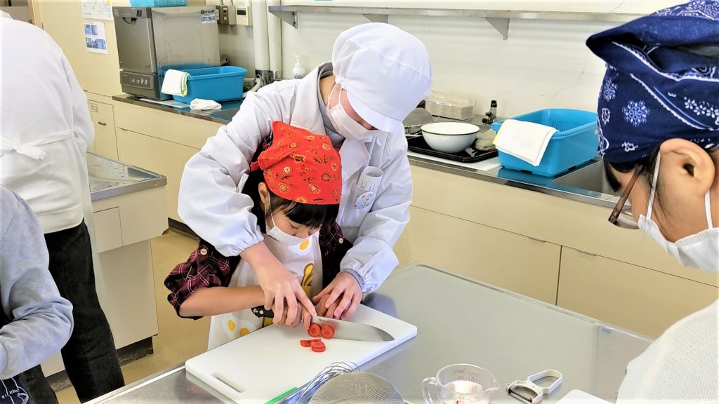 調理体験の補助をする学生